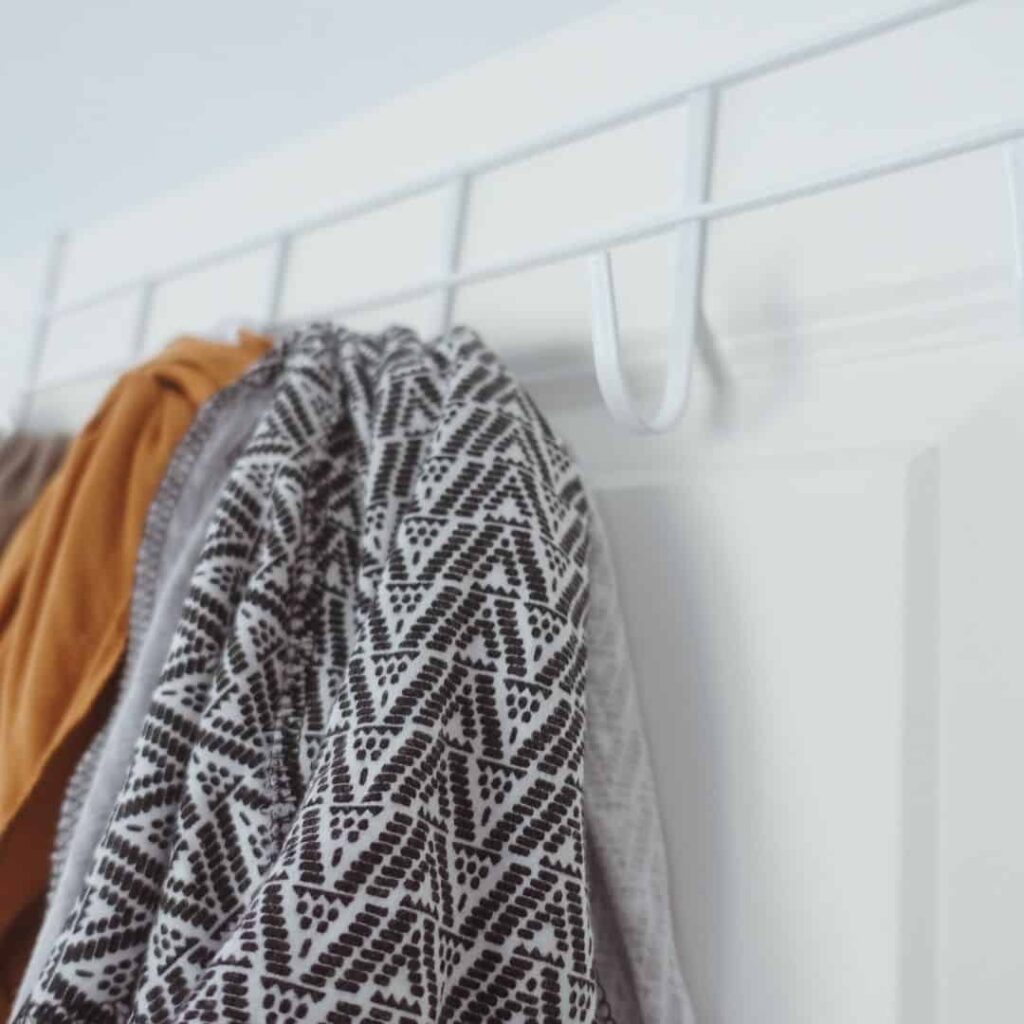 dollar store coat hanger for the door with 6 hooks holding baby wraps