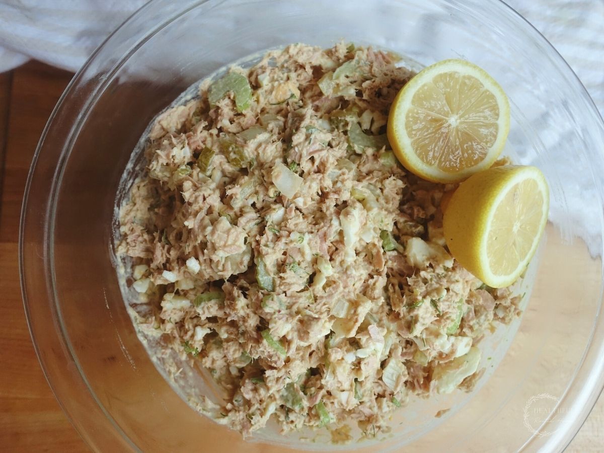 southern tuna salad with dill aioli with two lemons as garnish in a clear bowl