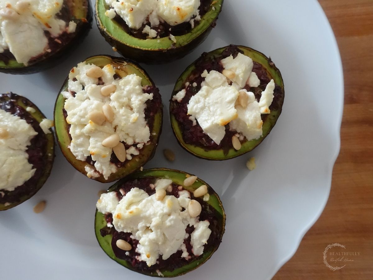 roasted avocados stuffed with goat cheese and kalamata olive tapenade on a white plate