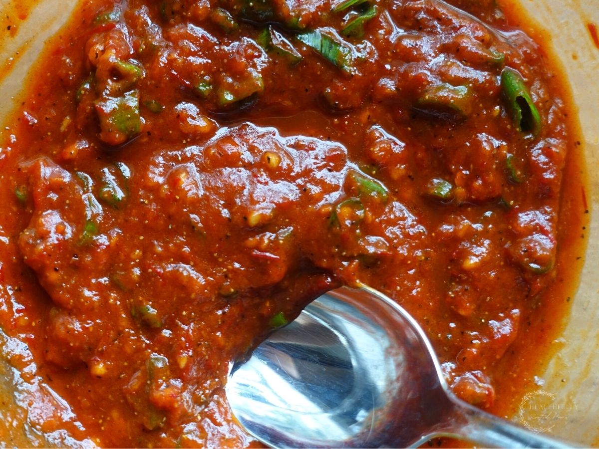 manchurian gravy sauce with a silver spoon scooping some out