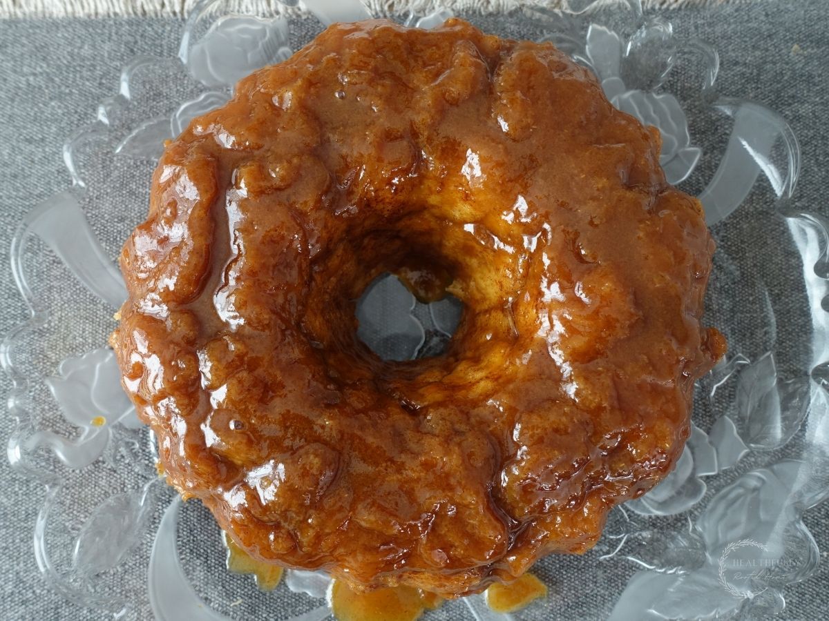 sourdough monkey bread on a serving platter with salted caramel sauce dripping off of it