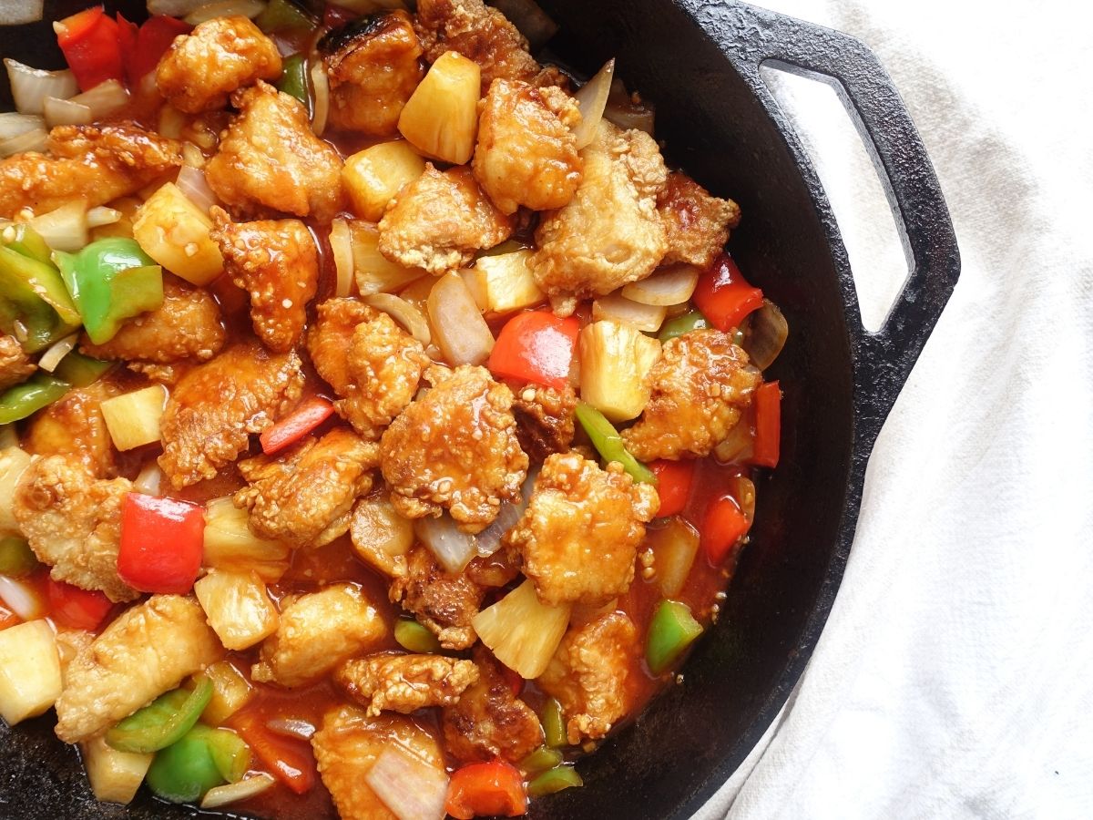 hong kong style sweet and sour chicken in a cast iron skillet