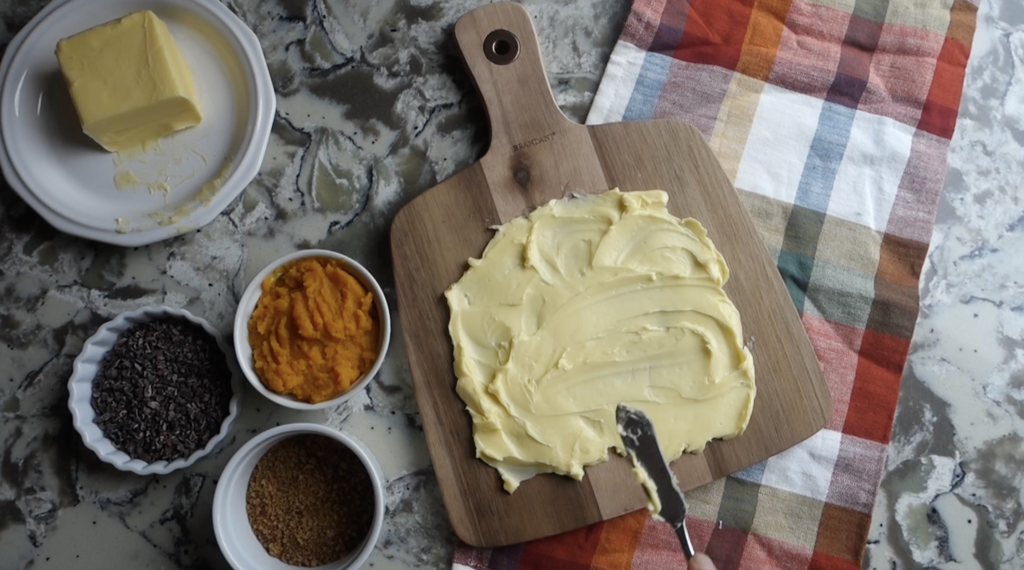 spreading butter on the board to make a pumpkin butter board