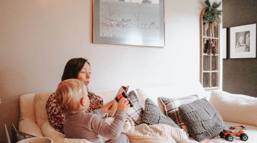 christian homemaker with her son on the couch reading the Bible