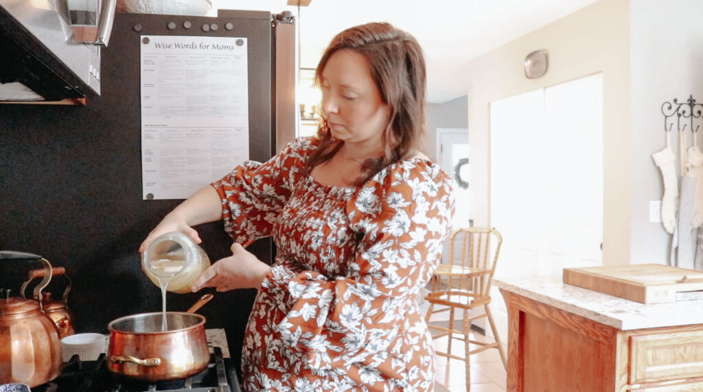 christian homemaker in a dress making bone broth in a copper pot