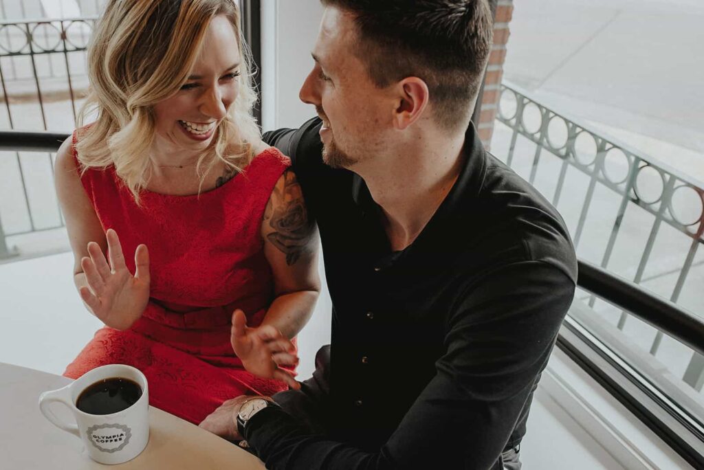 husband and wife laughing in a coffee shop enjoying their time together