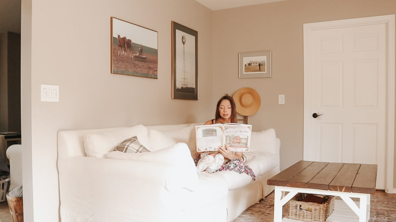 christian mother reading a book to child on a white couch