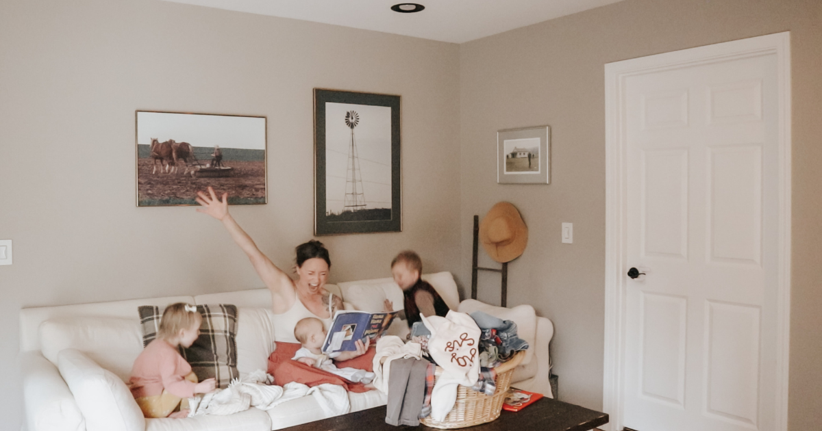 mother with three children reading a book on the couch celebrating victory