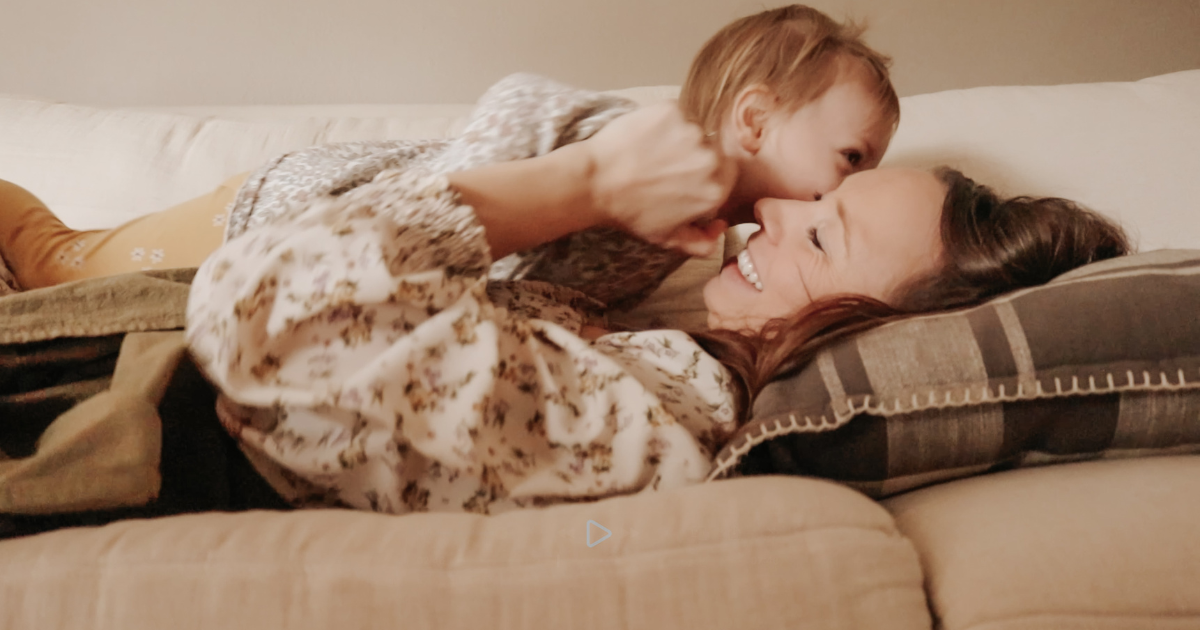 homemaker snuggling with daughter on the couch