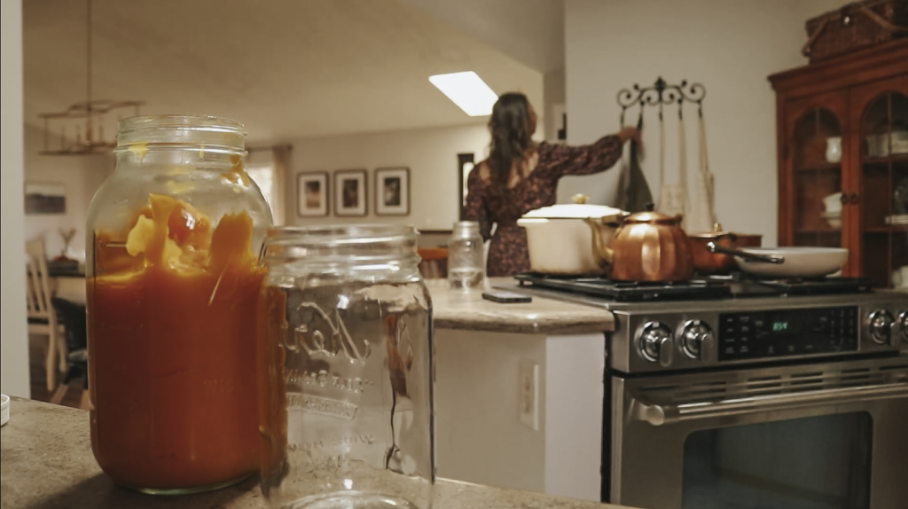 Christian homemaker is taking her apron off a hook on the wall in her kitchen.