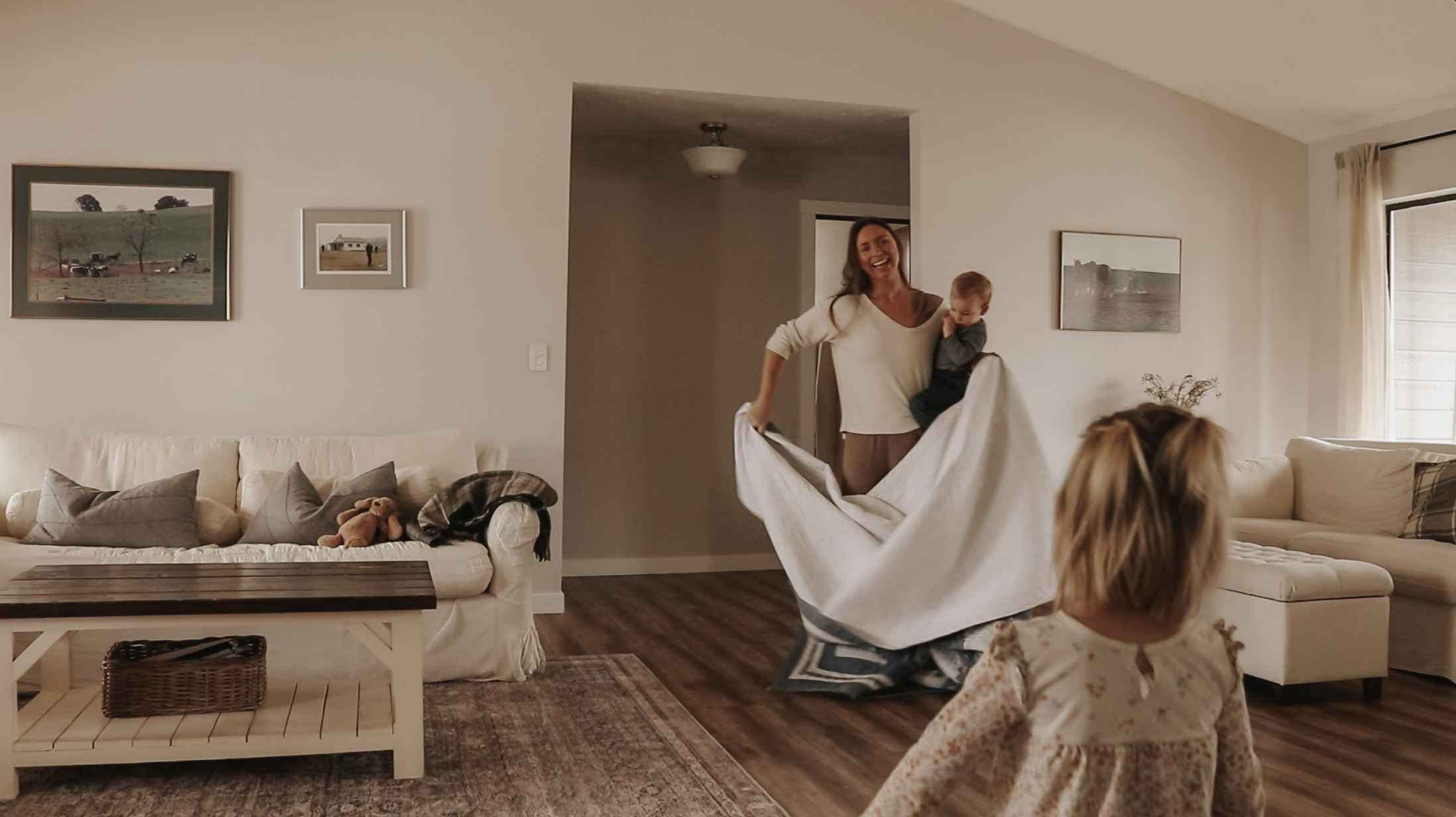 Homemaker and mother gets blanket out to lay on floor with baby on hip.