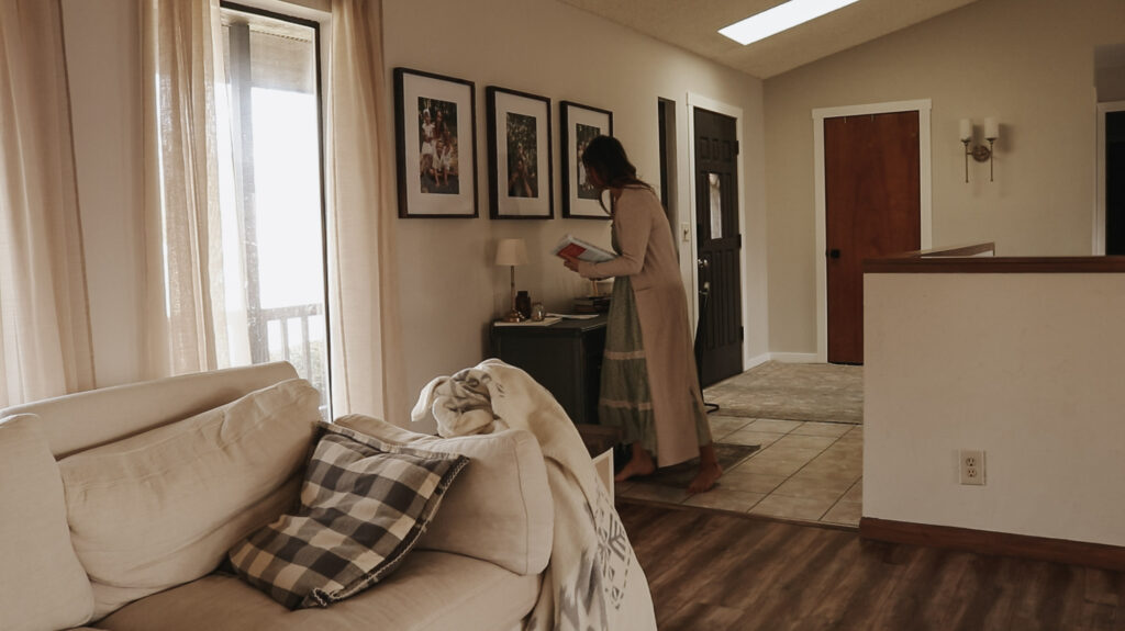 Homemaker stands over desk.