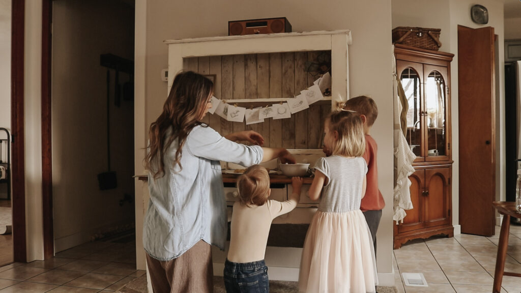 Christian mother and homemaker stands with her three children and makes cookies.