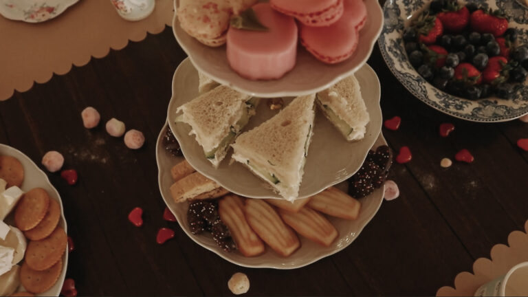 Tiered tray holds desserts on wooden dining room table.