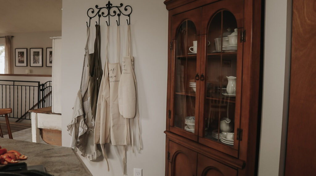 Aprons hang on wall in kitchen.