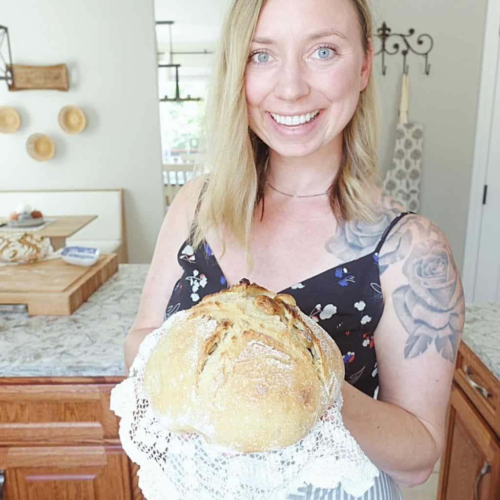 kyrie with healthfully rooted home holding roasted garlic sourdough bread on top of a lace doily