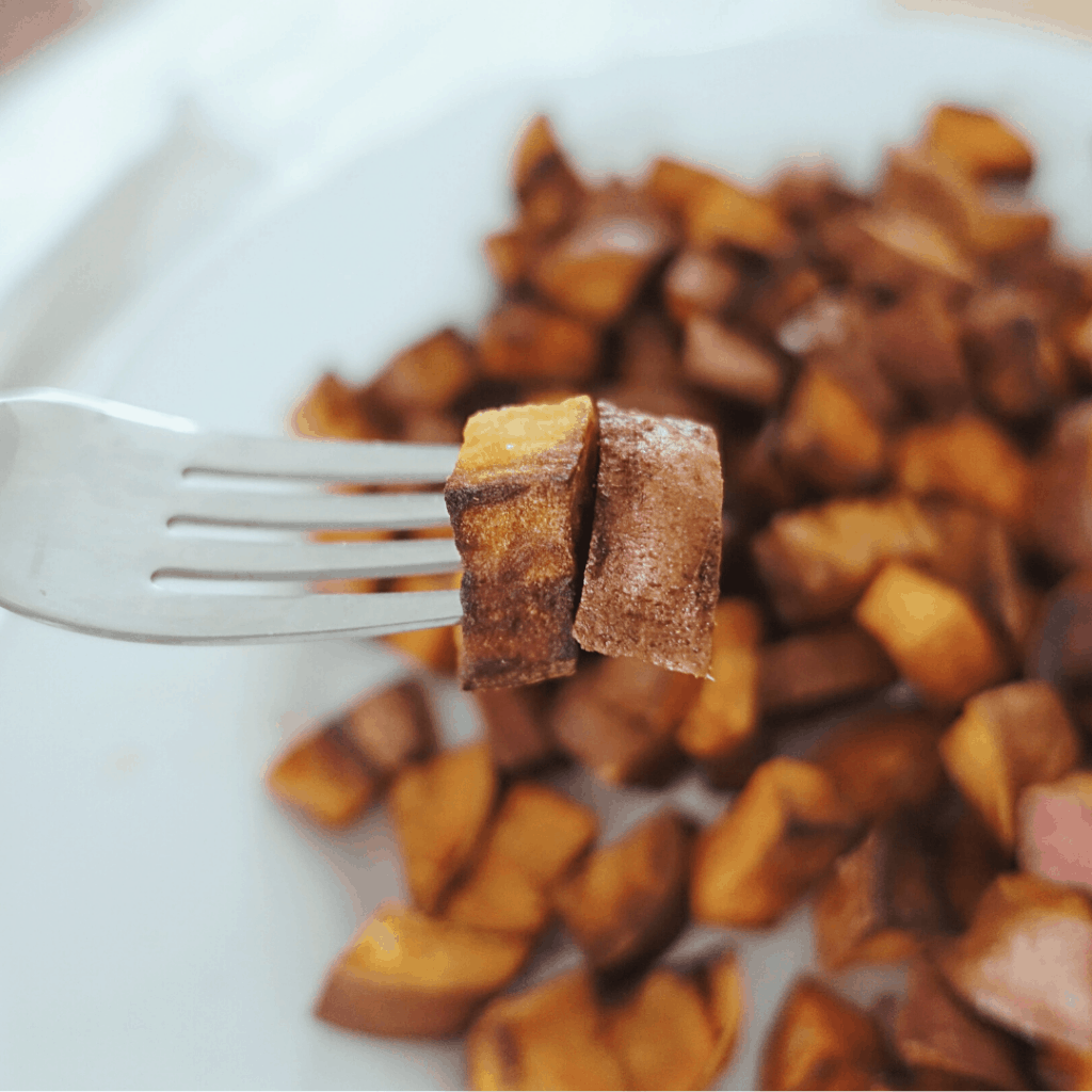 crispy sauteed sweet potatoes on a fork ready to eat