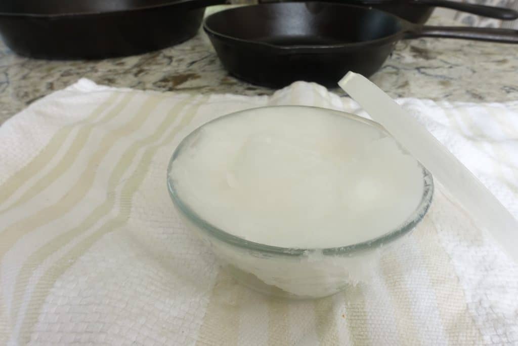 coconut oil on tea towel in front of nonstick cast iron skillets