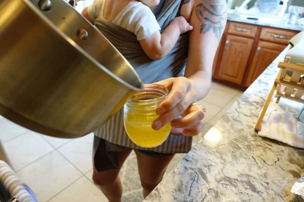 pouring homemade wood butter in a mason jar