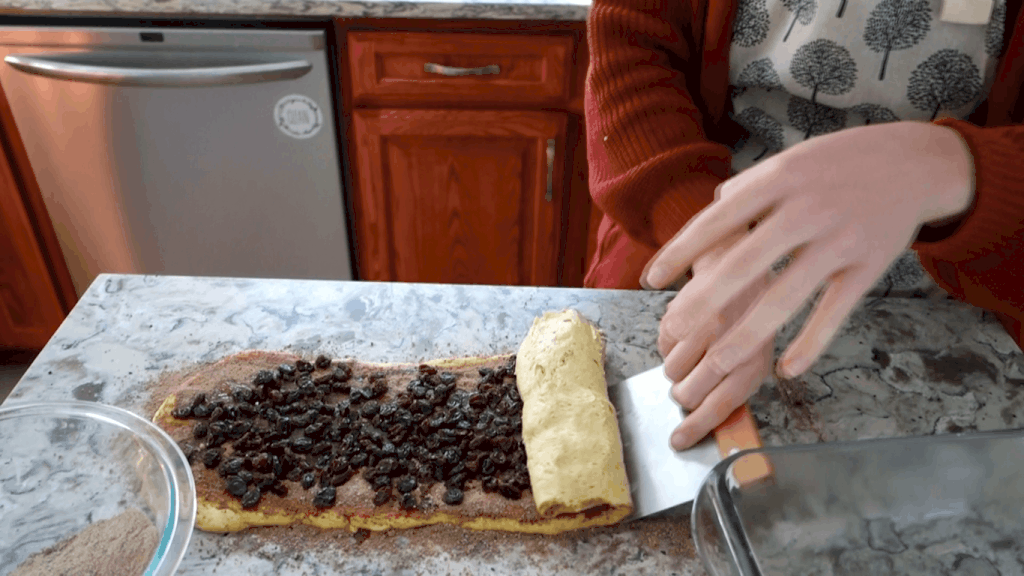 rolling the sourdough loaf with a dough scraper