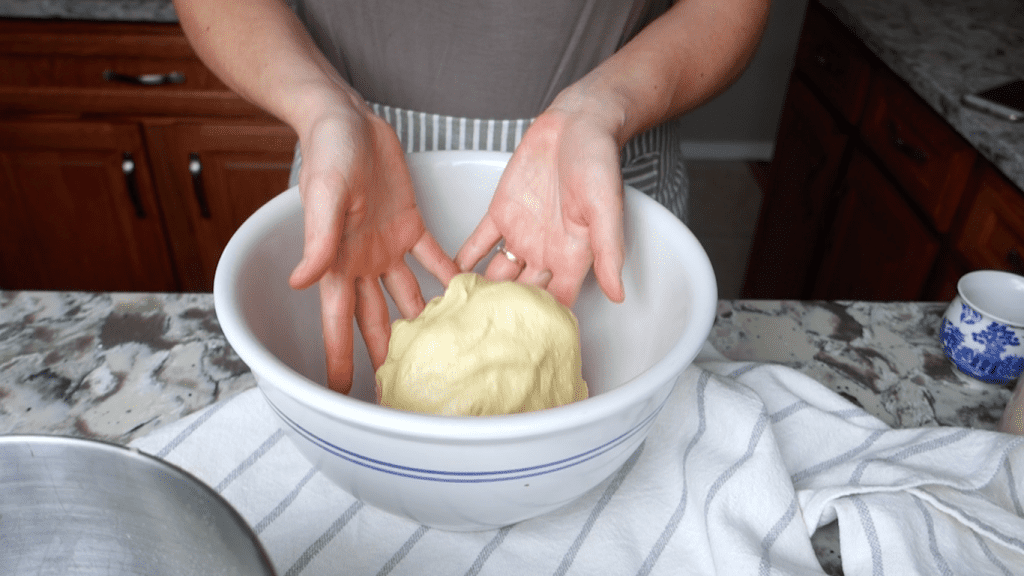 einkorn tortilla dough being transferred into a ceramic bowl