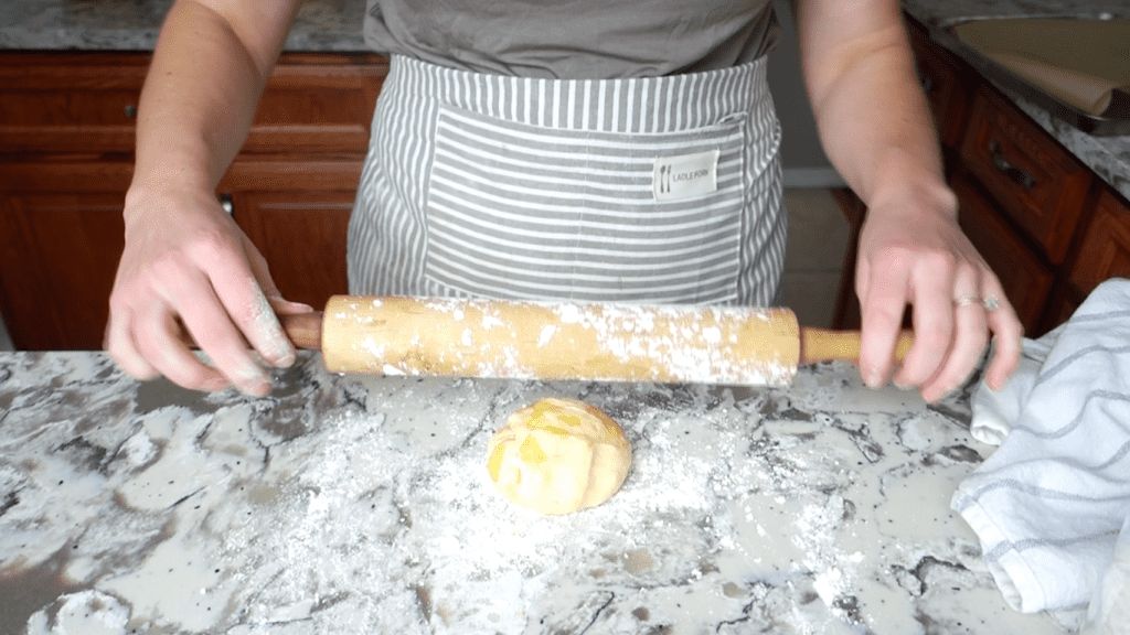 einkorn tortilla dough in a ball about to be rolled out with rolling pin