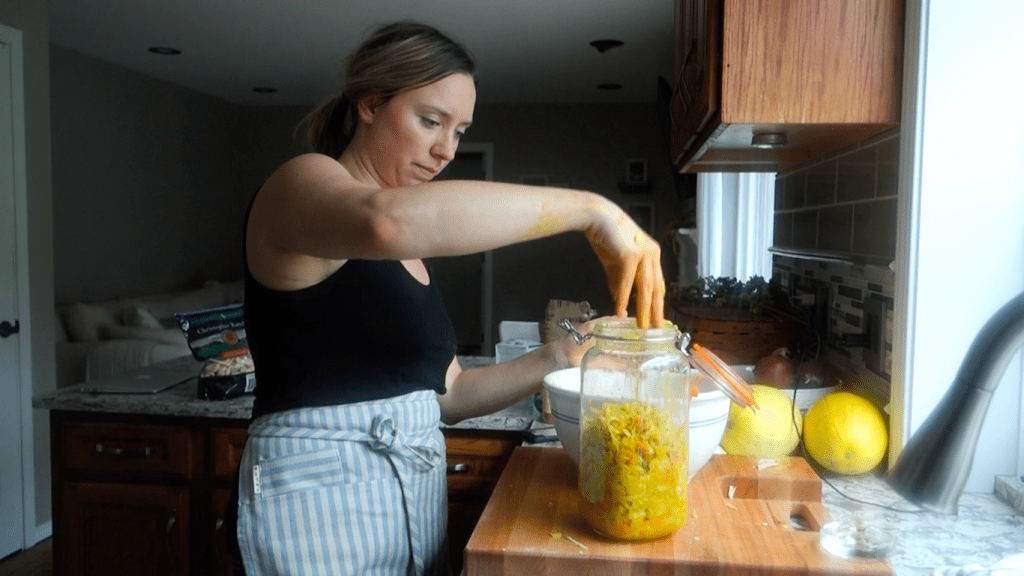 transferring the massaged curry kraut into a fermenting jar