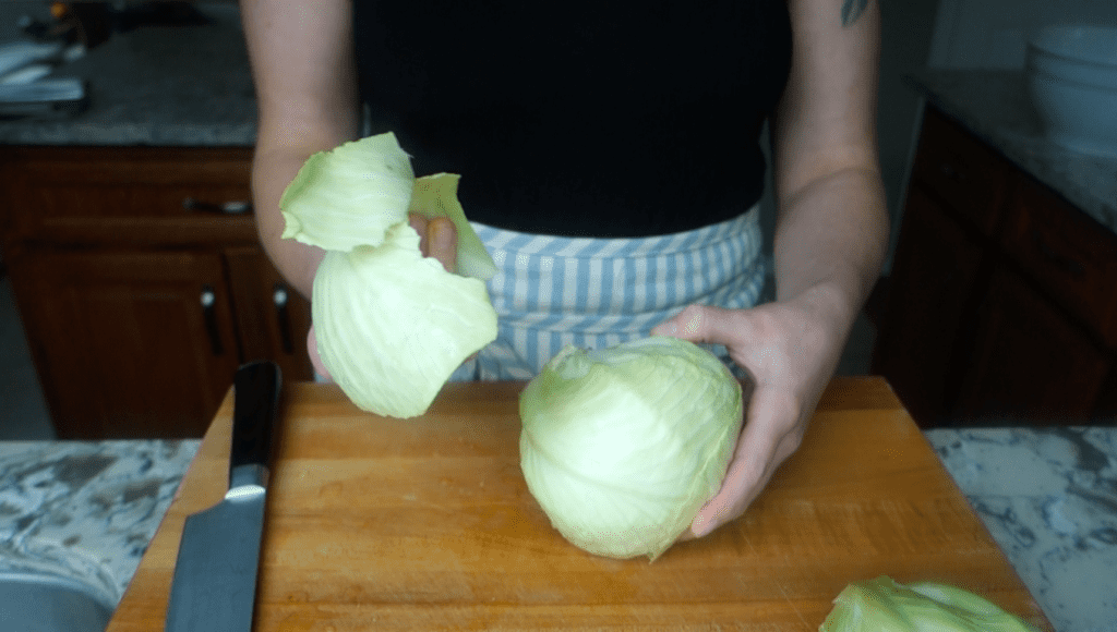 peeling the outer cabbage leaves off cabbage head