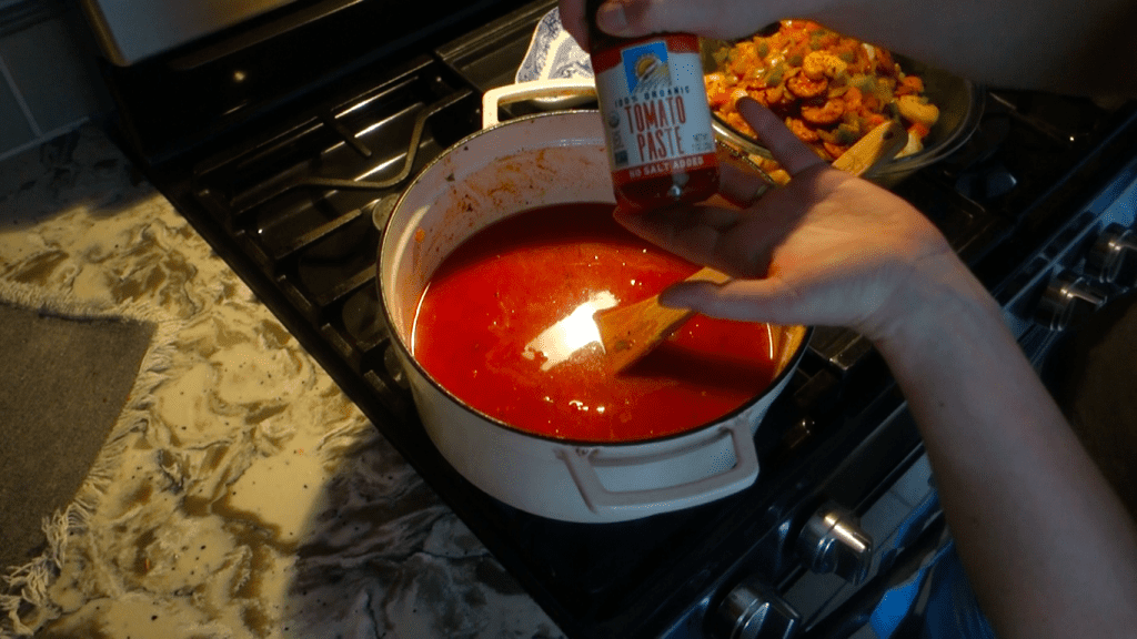 rice soaking in tomatoe sauce with a jar of tomato paste