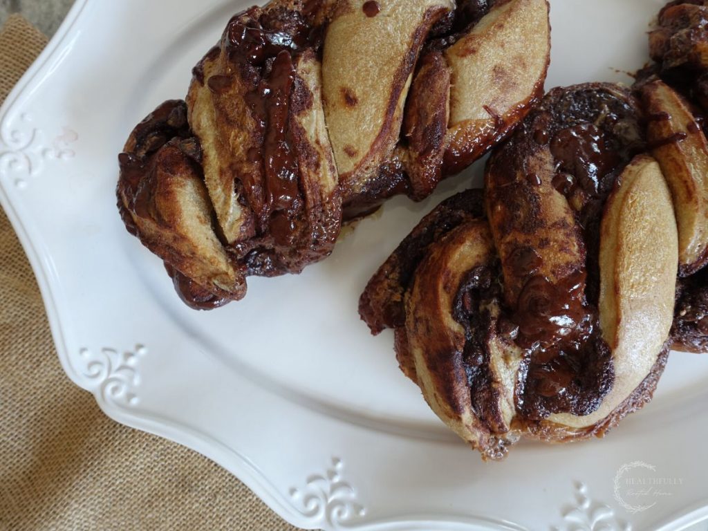 sourdough babka loaves on a white serving platter with burlap in the background