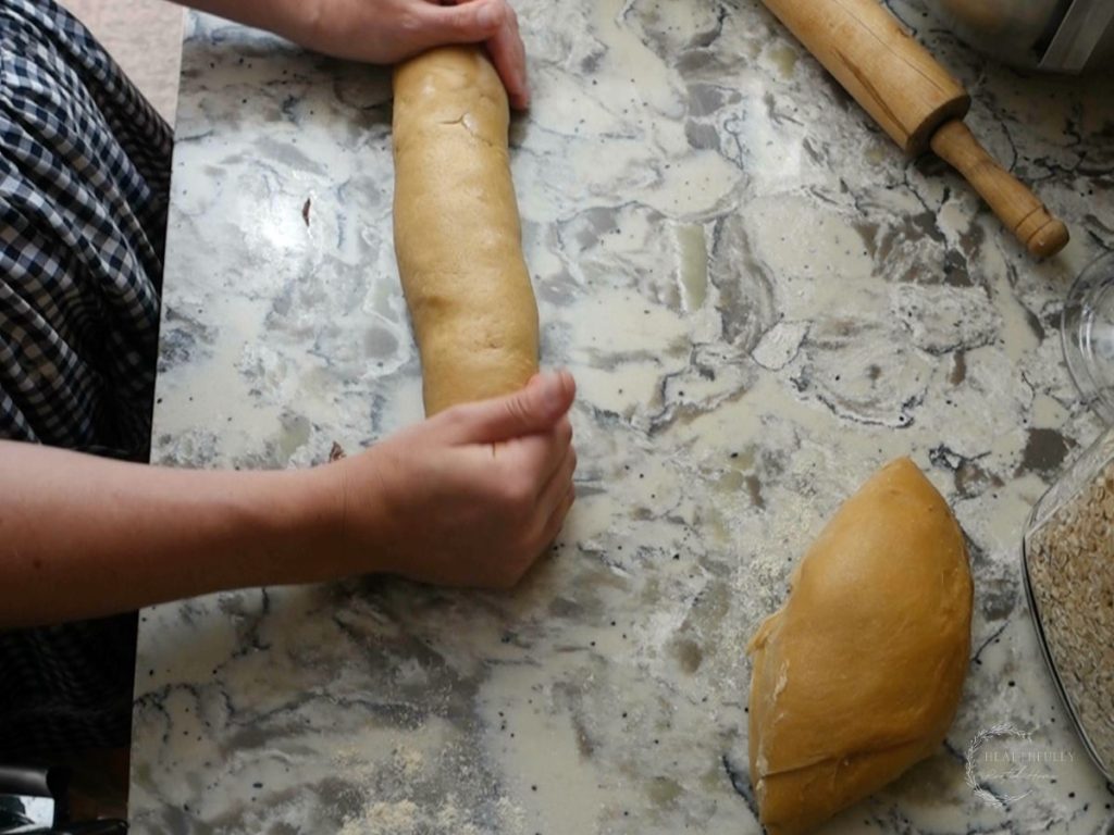 shaping the babka log after being filled with the chocolate and rolled up