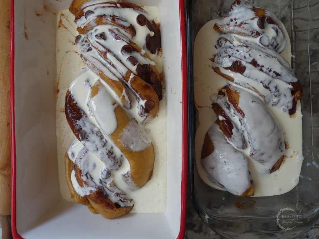 heavy cream poured overtop the sourdough babka loaves in the loaf pans
