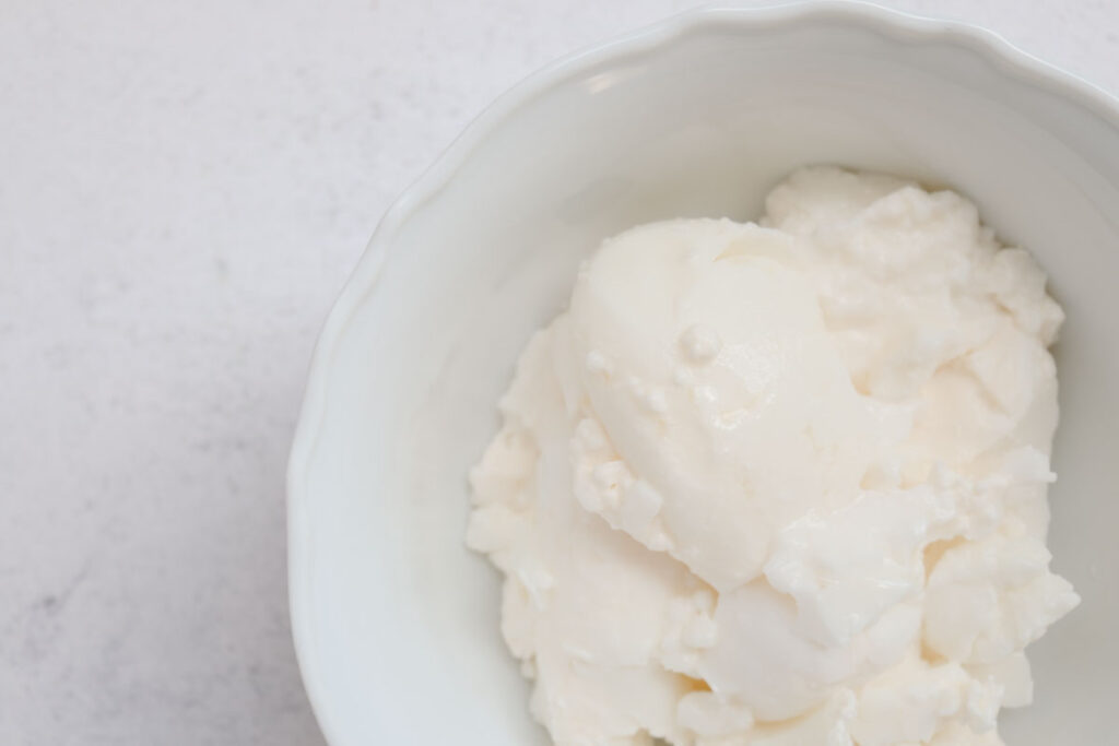 white bowl of greek yogurt shown as an option instead of applesauce for baking