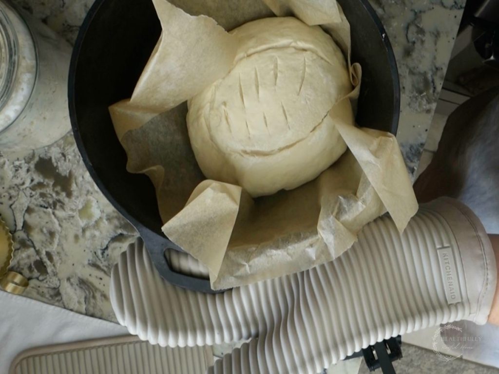 sourdough discard bread dough in a preheated dutch oven with parchment paper ready to be baked
