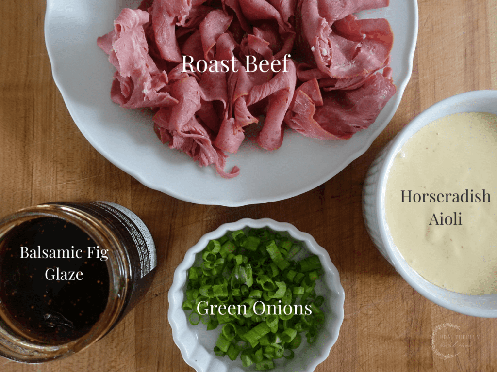 ingredients in white bowls on a wooden cutting board with labels for what they are