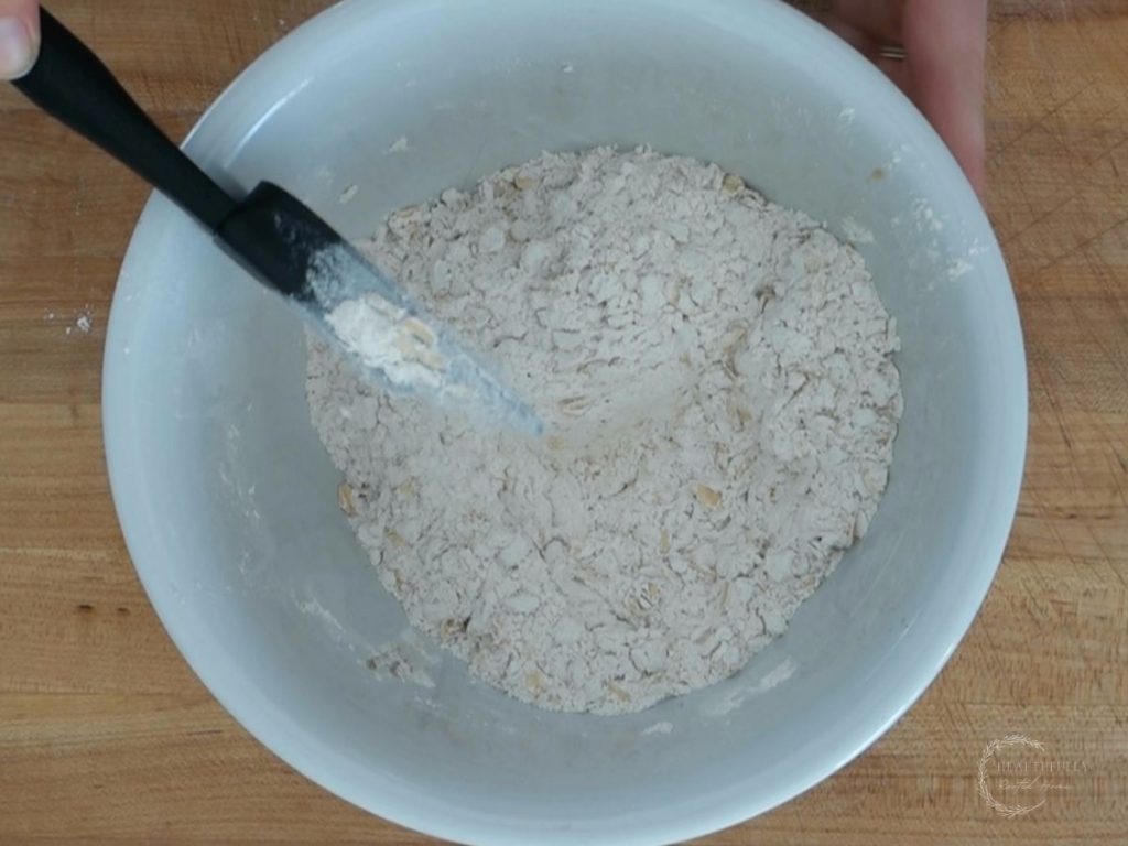 mixing the dry ingredients in a bowl for banana blueberry oatmeal muffins