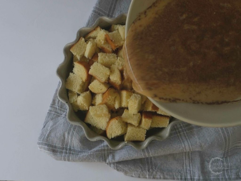 pouring custard overtop brioche bread for french toast casserole