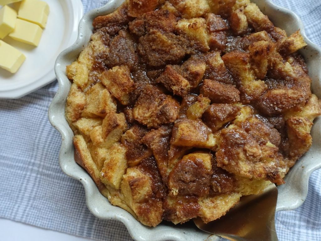 close up of baked brioche french toast casserole with a spatula inside