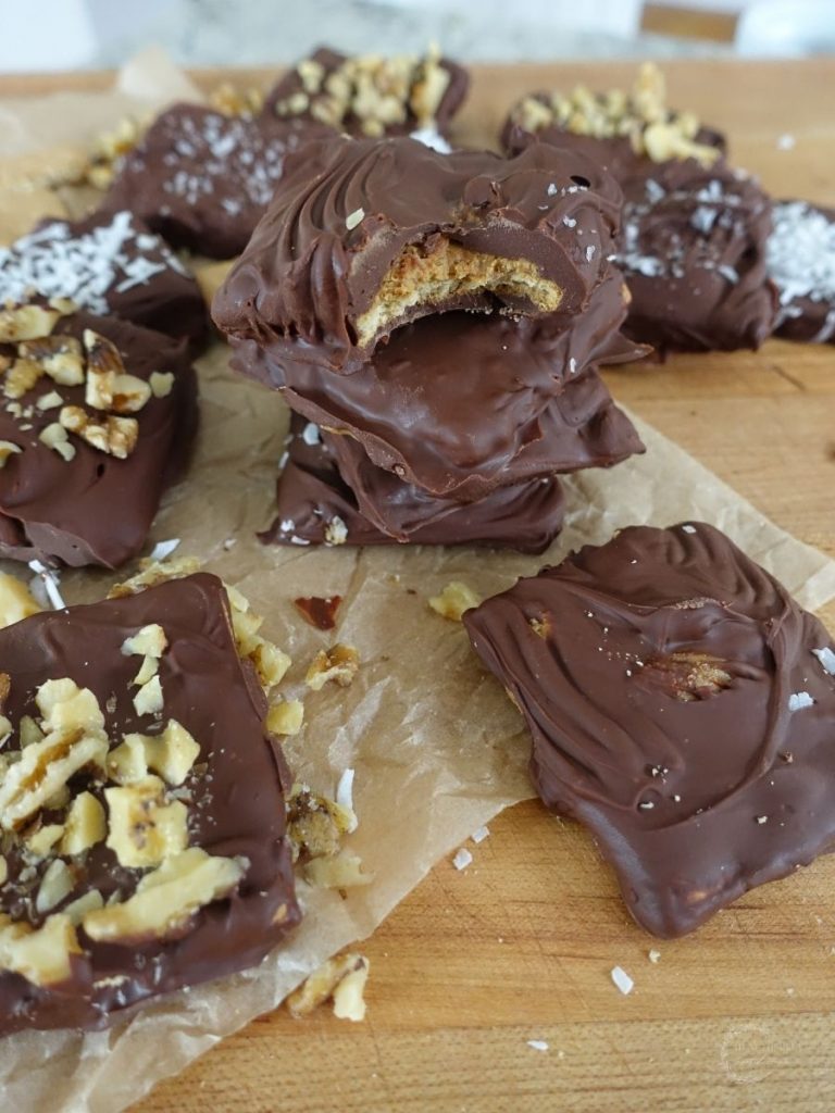 peanut butter stuffed chocolate covered graham crackers stacked on top eachother on top a piece of brown parchment paper