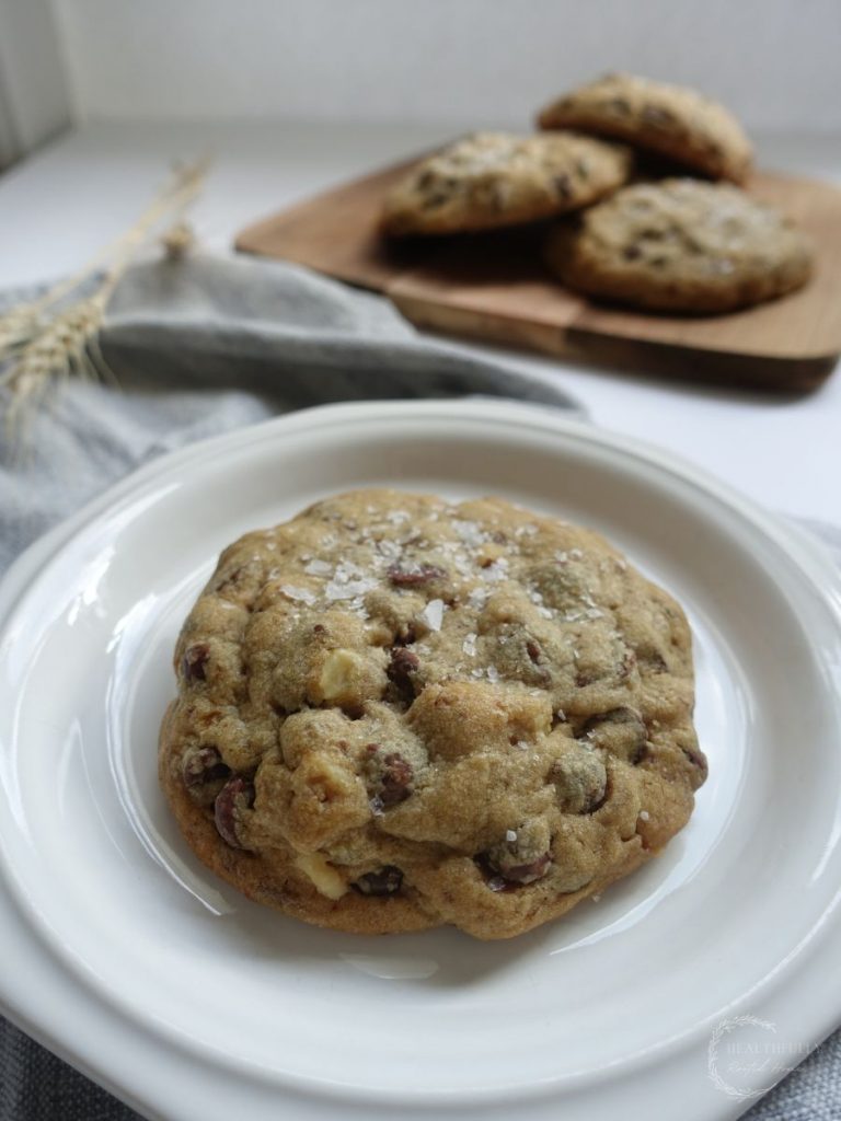 cookies without brown sugar stacked on eachother in the background with one in the front and center on a white plate