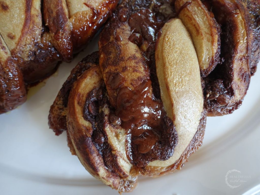chocolate filled sourdough babka loaf after being baked on a white platter
