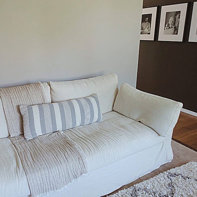decluttering tips for hoarders image of cream color slip covered couch with black wall