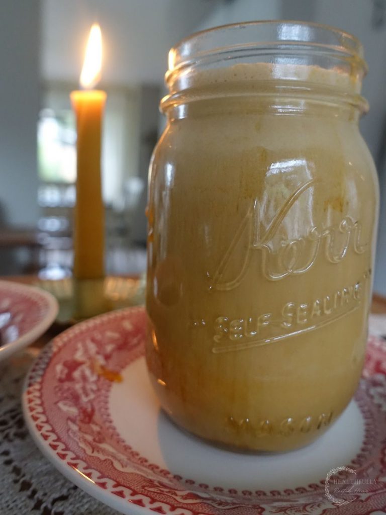 salted caramel cold foam cold brew in a mason jar with a candle in the background.