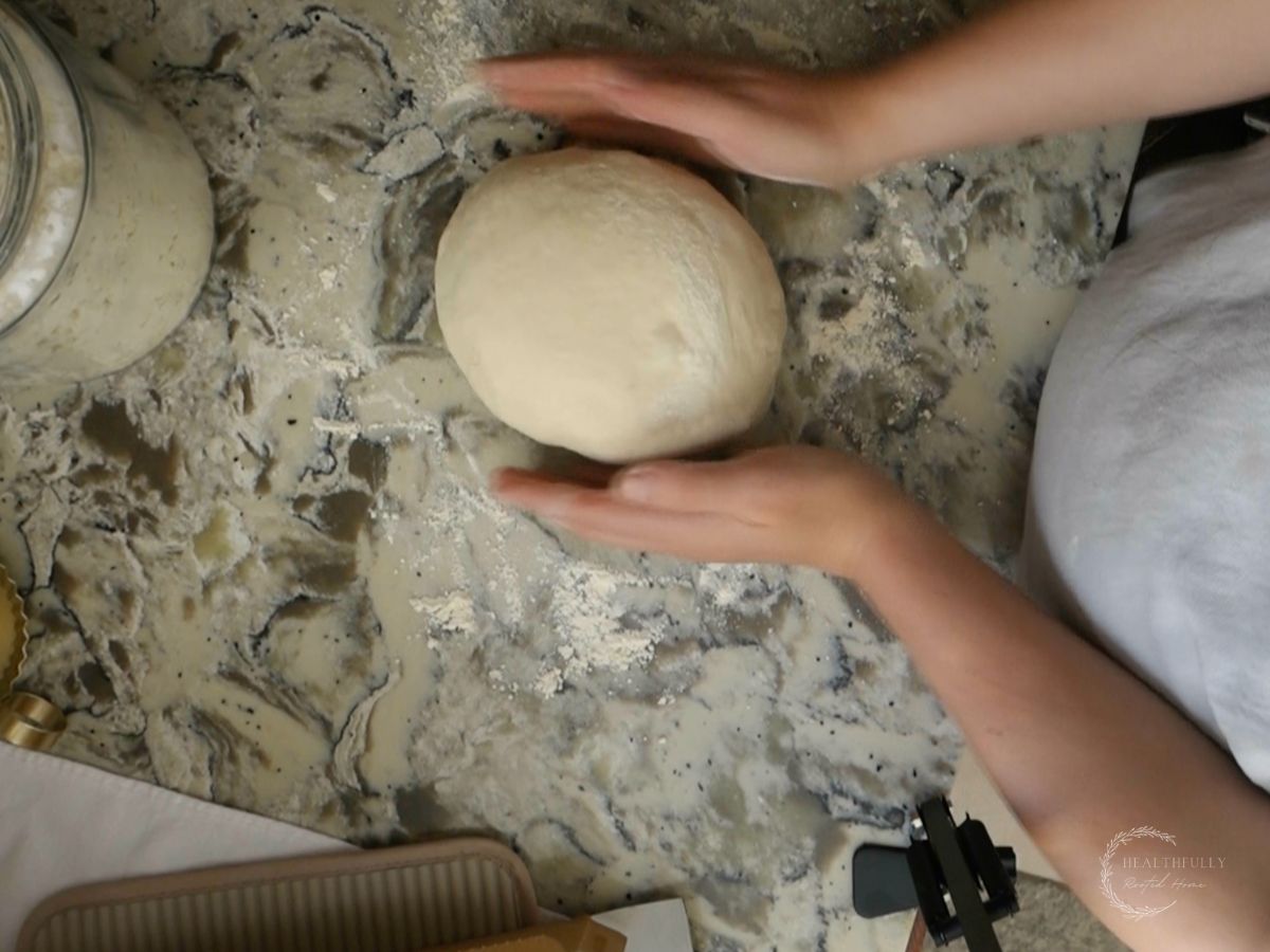 shaped sourdough discard bread in a round ball on the counter