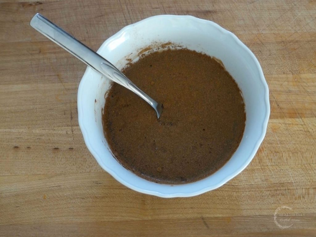 brine for fermented apples in a white bowl with a fork after being whisked