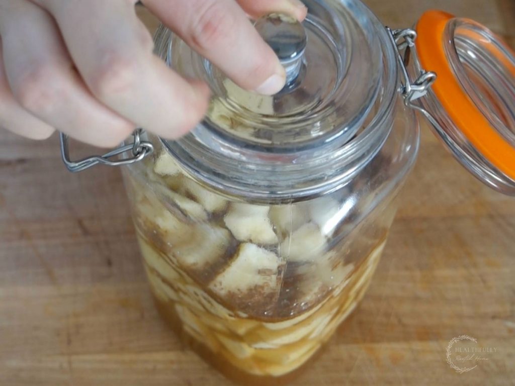 adding a fermentation weight to the jar of apples and brine