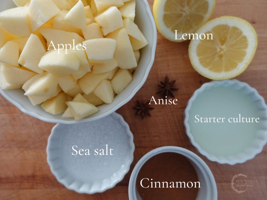ingredients for fermented apples in white bowls with labels say what each one is