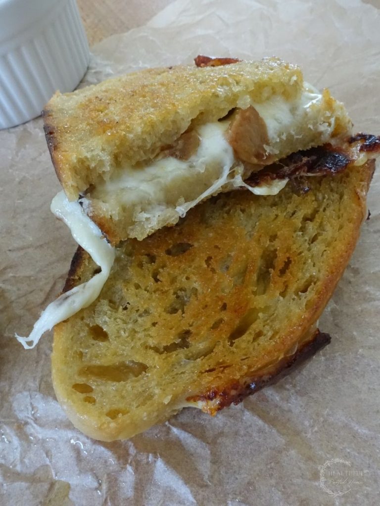 grilled cheese sandwich cut in half with provolone cheese spilling out