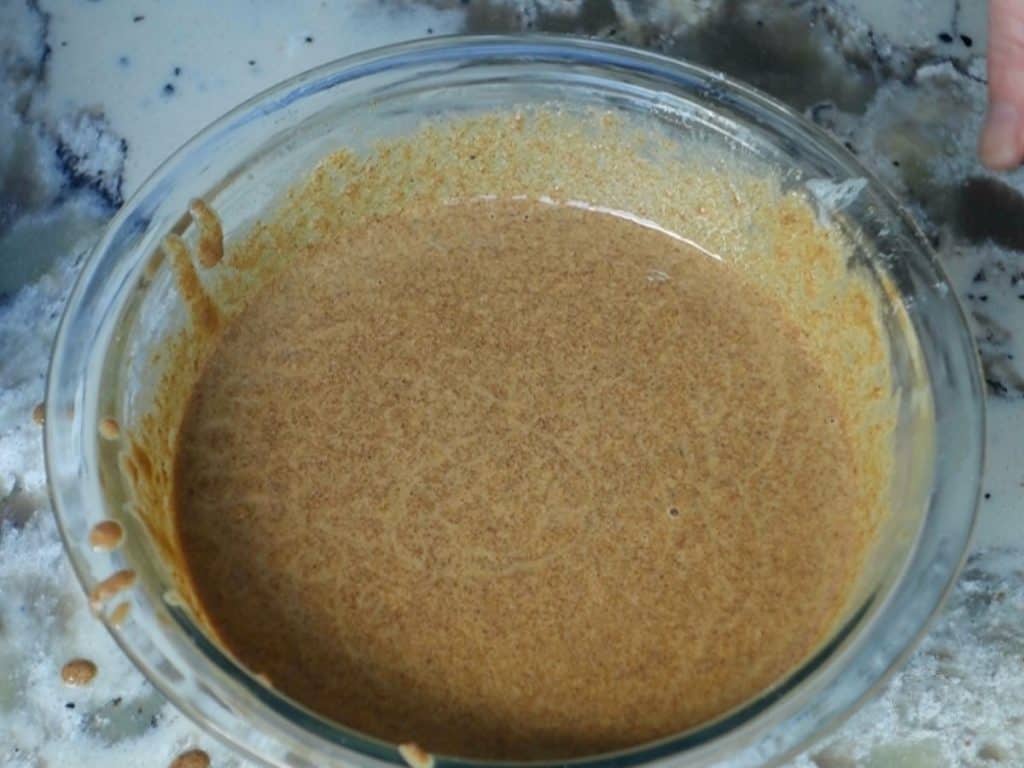 liquid ingredients combined in a large glass bowl on a granite countertop