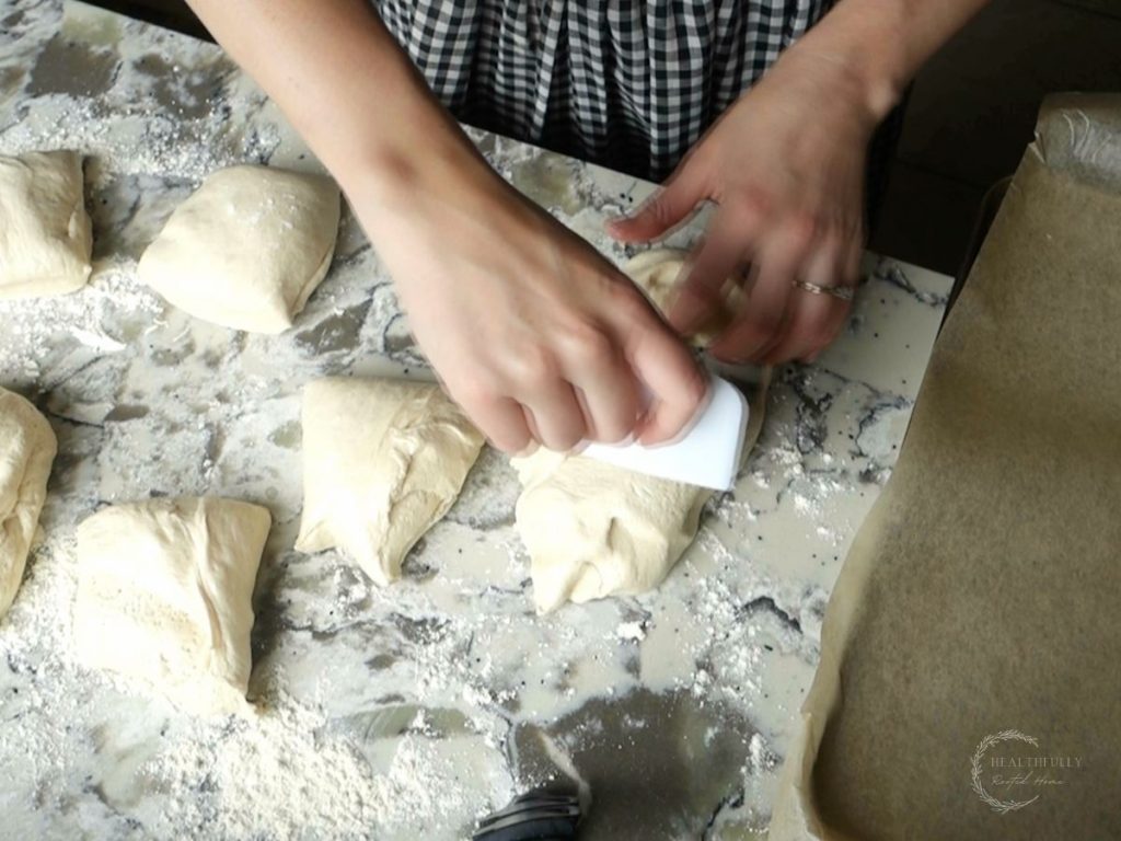 dividing sourdough discard bagel dough into pieces in order to shape into bagels